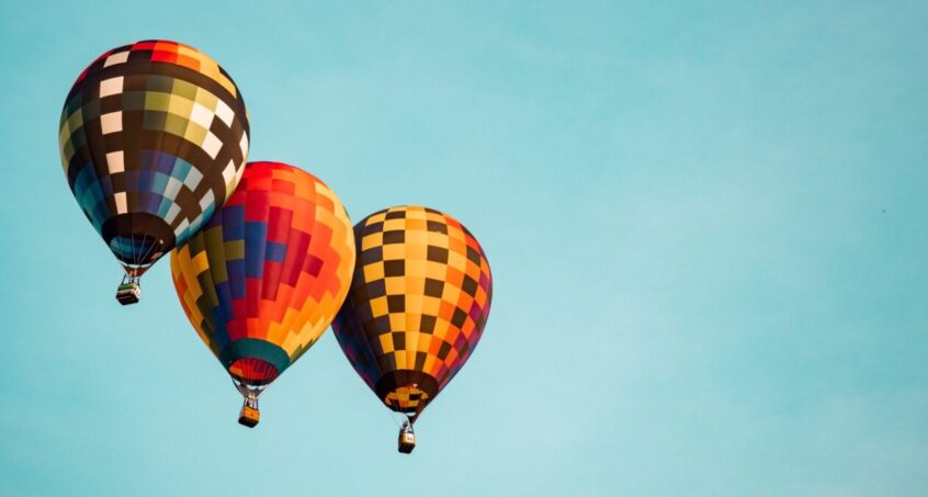three flying hot air balloons